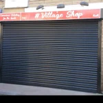 Black Roller Shutter Door over a Village Shop entrance