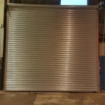Silver Roller Shutter Door at a factory entrance with a concrete floor